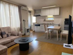 ein Wohnzimmer mit Sofa und Tisch in der Unterkunft Bon Clair in Sunagawa
