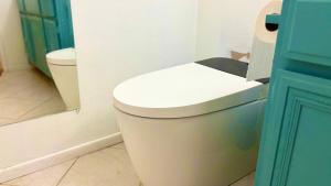 a white toilet in a bathroom with a blue door at Joshie home in Rancho Cucamonga