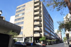 a tall brick building with a car parked in front of it at Hotel Universo in Guadalajara