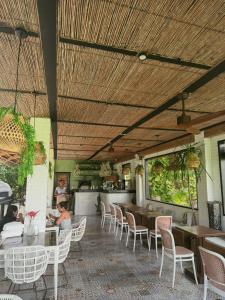 a restaurant with wooden ceilings and tables and chairs at JungleNest Resort in General Luna