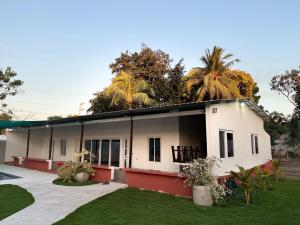 a white building with palm trees in the background at Monterrico VIP in La Candelaria
