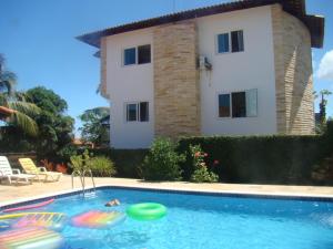 a villa with a swimming pool and a house at Casa Luxo em Enseada dos Corais Pernambuco próximo a Porto de Galinhas in Cabo de Santo Agostinho