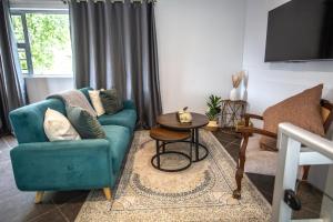a living room with a blue couch and a table at Luxury Suites on Santorini in East London