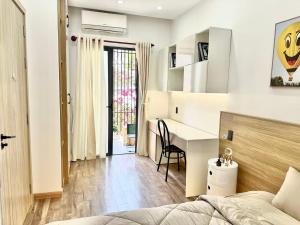a bedroom with a bed and a desk in a room at Hyn's House in Danang