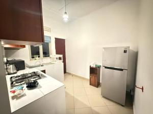 a kitchen with a refrigerator and a counter top at Apartment For Rent in Ambulgama