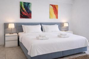 a bedroom with a large white bed with two lamps at White Tower Mamaia Beach 505 in Mamaia