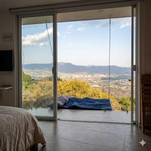 a bedroom with a large glass door with a view at Amanecer Ixtapan de la Sal in Ixtapan de la Sal