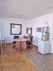 a room with a table and two chairs and a refrigerator at Amanecer Ixtapan de la Sal in Ixtapan de la Sal