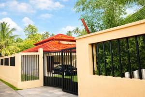 a gate to a house with a car behind it at Mara Villa Katunayake - 5 Mins to Colombo Airport in Katunayaka