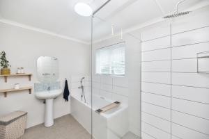 a white bathroom with a shower and a toilet at 32 Main Road in Struisbaai +21 photos