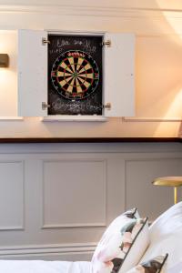 a dart board on a wall above a bed at Imperial Hotel Paddington in Sydney