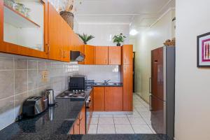 a kitchen with wooden cabinets and a refrigerator at Cabanas Del Mar 76 By Evermore in Kingsborough