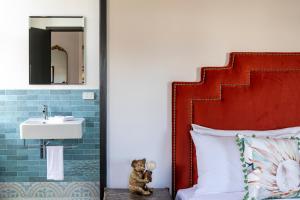 a teddy bear sitting next to a sink in a bedroom at Imperial Hotel Paddington in Sydney +71 photos