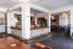 a bar with wooden tables and chairs in a restaurant at Imperial Hotel Paddington in Sydney