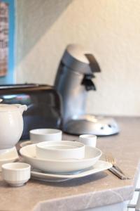 a counter with plates and cups and a coffee maker at Das Rübezahl in Bad Elster +9 photos