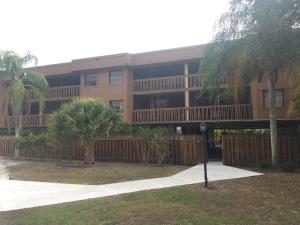 un gran edificio de apartamentos con balcón y palmeras en Charlotte Bay Resort, en Port Charlotte