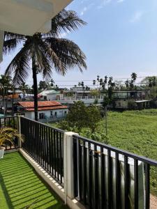 a balcony with a view of a palm tree at Green Stay , AC room in Sibsāgar