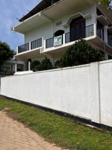 a white fence in front of a building at Green Stay , AC room in Sibsāgar +4 photos