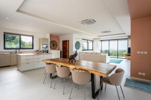 a kitchen and dining room with a wooden table and chairs at Titine Villa in Srithanu