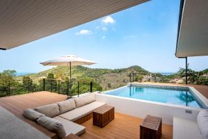 a living room with a couch and a swimming pool at Titine Villa in Srithanu