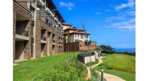 een buitenaanzicht van een gebouw met een grasveld bij 418 Zimbali Suites in Ballito