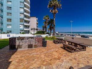 a picnic table and benches next to the beach at 75 Cap D'Azur in Strand