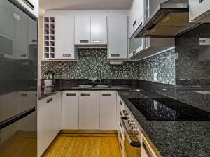 a kitchen with white cabinets and black counter tops at 75 Cap D'Azur in Strand