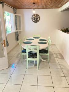 a dining room with a table and chairs and a clock at Cascade Grand-Galet à 2 min -Maison entière -La Kase de la Cascade- Rivière Langevin in Saint-Joseph +23 photos
