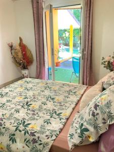 a bed with a flowered comforter in a bedroom at Cascade Grand-Galet à 2 min -Maison entière -La Kase de la Cascade- Rivière Langevin in Saint-Joseph