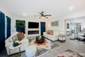 a living room with a white couch and a tv at Luxury Stay Near Downtown Bakersfield in Bakersfield