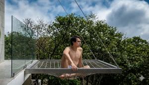 a man sitting in a hammock on a roof at Amanecer Ixtapan de la Sal in Ixtapan de la Sal +2 photos