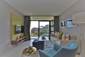 a living room with a couch and a tv at 204 Zimbali Suites in Ballito