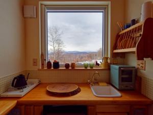 a kitchen counter with a window with a view at Sauna Paistaa in Sobetsu
