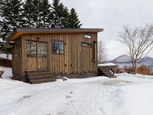 a small wooden cabin in the snow with trees at Sauna Paistaa in Sobetsu +28 photos