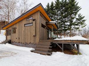 a small wooden building with snow on the ground at Sauna Paistaa in Sobetsu