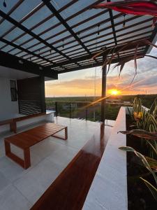 a patio with a bench and a sunset in the background at Roys Suites Galapagos in Puerto Ayora