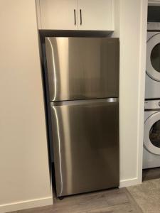 a stainless steel refrigerator in the corner of a kitchen at Modern Comfort in Calgary