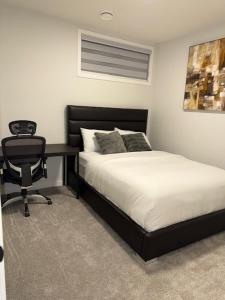 a bedroom with a bed and a desk and a chair at Modern Comfort in Calgary