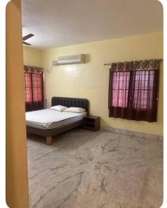a bedroom with a bed and two windows at Trichy homestays in Tiruchirappalli