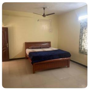 a bedroom with a bed with a ceiling fan at Trichy homestays in Tiruchirappalli +7 photos