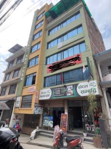 a building with a sign on the side of it at Hotel Sambridhi in Panepa