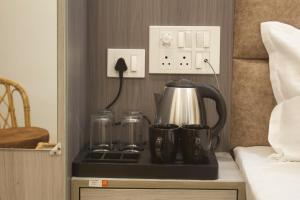 a coffee pot and two cups on a tray on a night stand at Hotel Kedarkhand in Sonprayag +17 photos