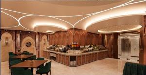 a restaurant with wooden walls and green chairs and tables at Monsoon Courtyard Luxury Hotel in Dhaka