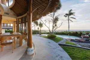 an outdoor patio with a table and chairs and a pool at La Joya Balangan Resort in Jimbaran