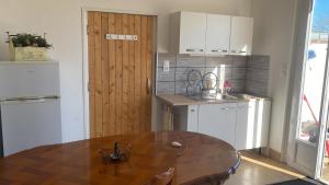 a kitchen with a table and a wooden door at Champvert in Champvert