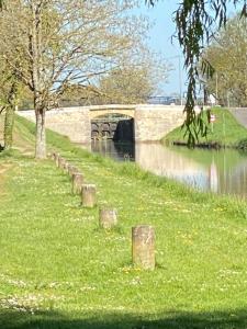 a bridge over a river with a grassy field at Champvert in Champvert