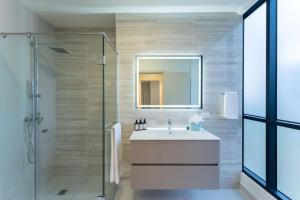 a bathroom with a sink and a shower with a mirror at Deluxe Loft Apt with City View in Panama City