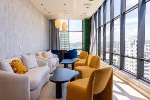 a living room with couches and chairs and large windows at Deluxe Loft Apt with City View in Panama City +15 photos
