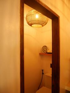a bathroom with a toilet with a light above it at Terracotta tropical nest in San Vicente