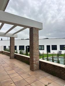 a patio with a pavilion and a white building at El Puente de Sansueña in Córdoba